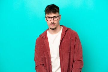 Young caucasian handsome man isolated on blue background with sad expression