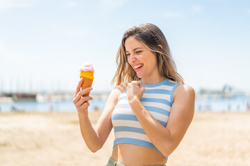 Young pretty woman with a cornet ice cream at outdoors celebrating a victory