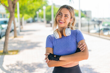 Young pretty sport woman at outdoors looking up while smiling