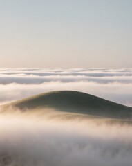 Obraz premium A whimsical hill under a blanket of clouds in the morning.