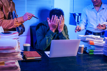 Three men work overtime at night, stressed and overloaded with tasks. They are exhausted, checking...