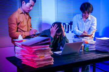 Three men work overtime at night, stressed and overloaded with tasks. They are exhausted, checking...