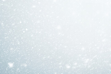 Fototapeta premium Snowflakes falling softly on a textured, light background.