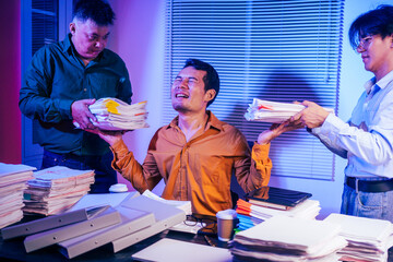 Three men work overtime at night, stressed and overloaded with tasks. They are exhausted, checking...
