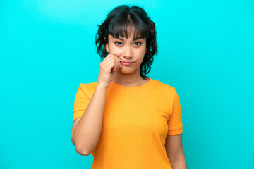 Young Argentinian woman isolated on blue background showing a sign of silence gesture
