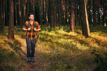 Man walking with backpack hiking in forest