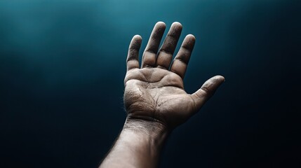 Close-up of an outstretched hand with fingers open against a dark teal background, emphasizing the texture and details of the skin.