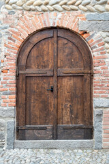 Italia, Ricetto di Candelo. Panorama di borgo medievale. Storia e cultura di Italia e d'Europa. Porta in legno isolata in primo piano.