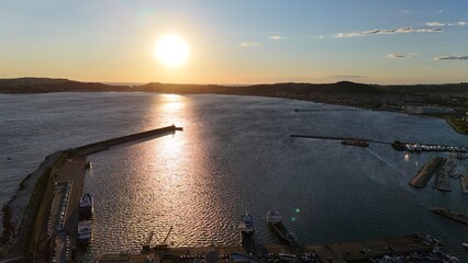 A stunning aerial shot of Pozzuoli, highlighting its scenic coastline and vibrant harbor.The drone...