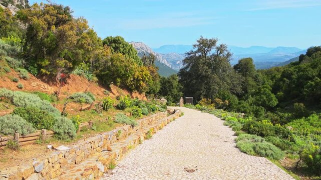 Gorropu canyon hiking trail path, hike to famous rocky gorge in Sardinia with Sardinian mountains cliff nature forest landscape in summer of Italy