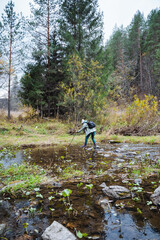 A person is meticulously and cautiously crossing a stunningly beautiful stream that flows gently...