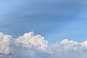 Large clouds in a bright blue sky with sunlight.
