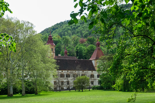 Grand imposing Baroque-style castle Eggenberg surrounded by lush greenery in Graz, Styria, Austria, Europe. Facade with intricate details, symmetrical design, and a central dome. Styrian State Museum