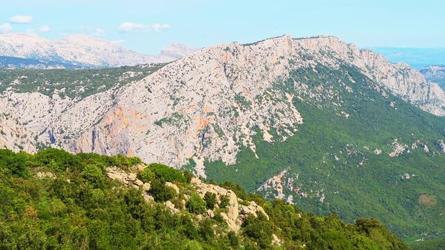 Gorropu canyon hiking trail valley to famous gorge in Sardinia with Sardinian mountains cliff forest landscape, panning shot in summer of Italy