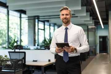 Handsome businessman using his tablet in the office