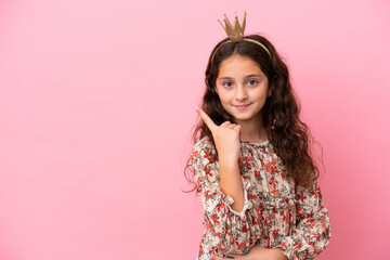 Little caucasian princess with crown isolated on pink background with shocked facial expression