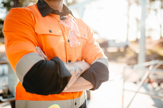 A man standing with arms crossed on construction site