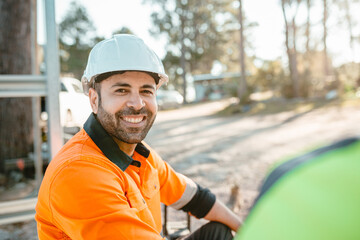 Closeup of a construction worker sitting on the ground of the construction site.