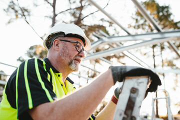 Construction worker climbing up steel ladder on worksite