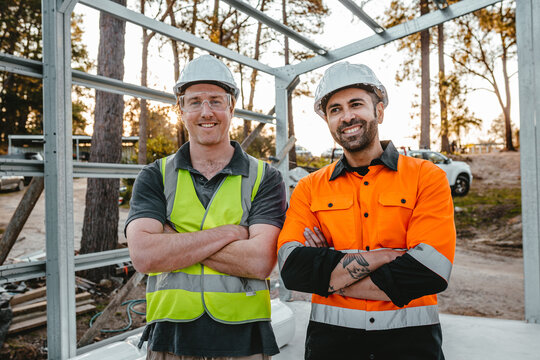 Portrait of builders with arms crossed at the construction site.