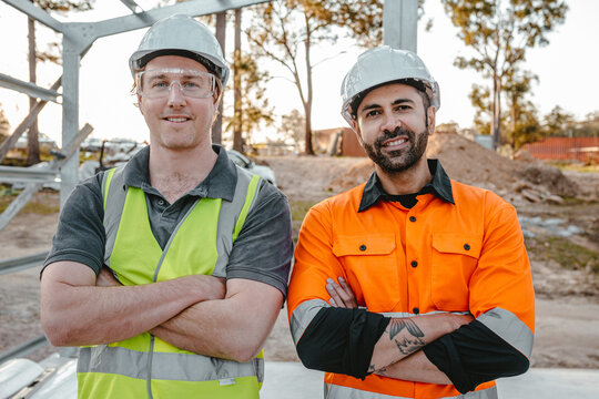 Portrait of builders with arms crossed at the construction site.