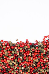 Red, green, white and black peppercorns on a white background, copy space for text