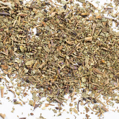 Dry basil spice seasoning macro texture on white background.