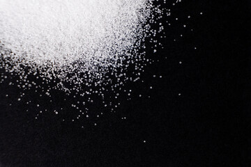 Macro crystals of white rock edible salt on black background space for text