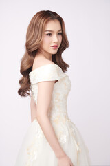 Beautiful young asian woman in wedding dress on white background,