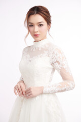 Beautiful young asian woman in wedding dress on white background,