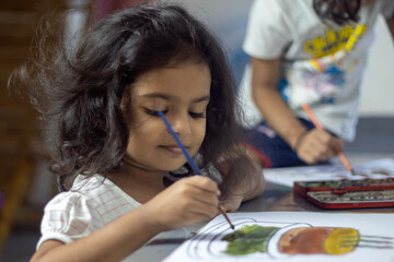 Close up of little girl playing with water color.