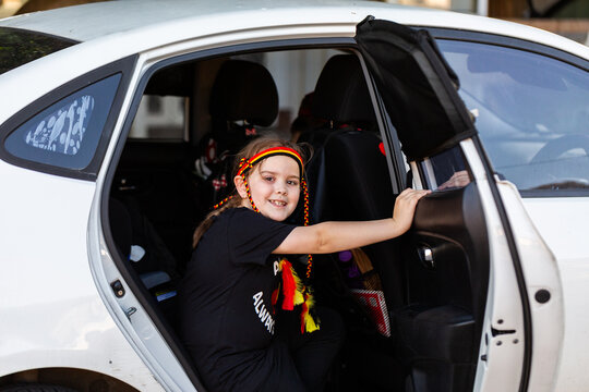 Seven year old Aboriginal Worimi girl getting into family car for trip