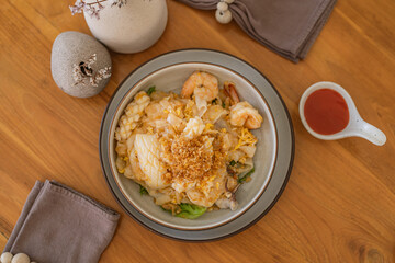 Top view of Appetizing Thai Stir-Fried Rice Noodles with Seafood (Kuay Tiew Kua Talay) - Delicious Traditional Dish with Shrimp, fish and squid.