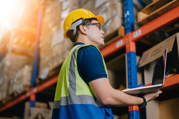 Two warehouse workers using a digital tablet while recording inventory. Logistics employees working with warehouse management software in a large distribution centre.