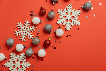 Red Christmas background with snowflakes and glitter ornaments. Christmas and Happy New Year celebration concept. Top view