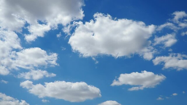 Beautiful white clouds in the sunny blue sky. Volumetric light effect. Convection in the troposphere. Real time slow motion. Cumulus clouds low-level, puffy, cotton-like, fluffy Cumulonimbus