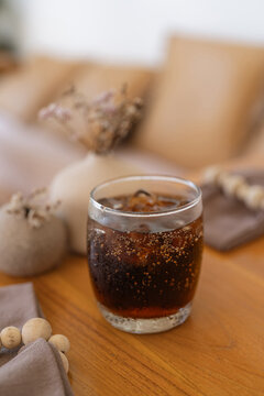 Refreshing Glass of Chilled Cola with Ice - Classic Carbonated Soft Drink on a Wooden Table