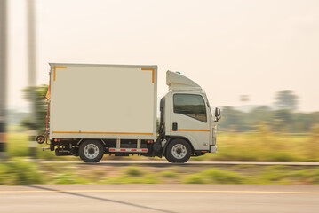 Side view of a small truck driving on a country road, truck running on the road, small truck on the road.