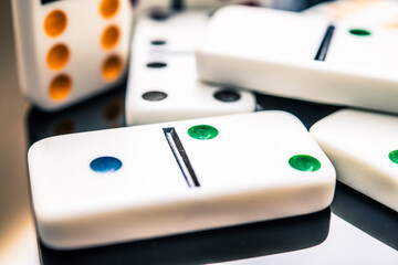 Colorful Dominoes on Glossy Surface - A Close-Up View of Classic Game Pieces, Capturing Strategy, Fun and Social Interaction while Playing with Friends or Family