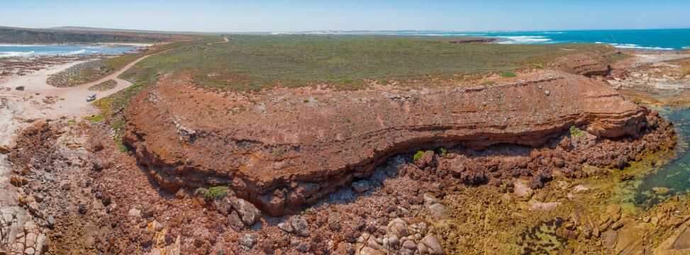 Aerial panorama of an eroded coastal plateau flanked by rockpools