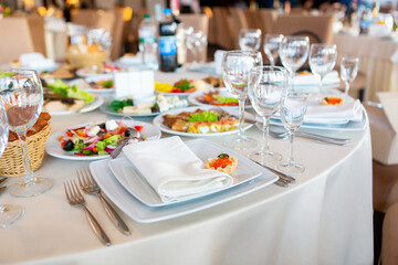 Elegant Dining Setup With Assorted Dishes and Drinks at a Banquet Hall During Evening Event