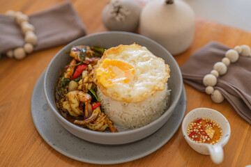 Stir-Fried Thai Basil Seafood with Rice and Fried Egg - Traditional Thai Street Food Dish.