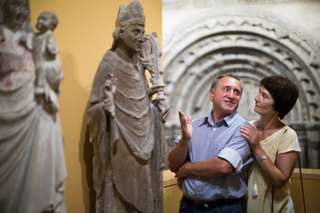 Middle aged men and women collector evaluates the exhibition inl museum