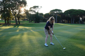 woman playing golf on the green fairway course