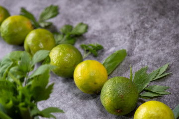 grüne und gelbe Limetten in einer Herzform mit Kräuter