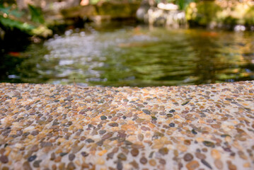 Pebble Stone Texture with Blurred Pond in Background.