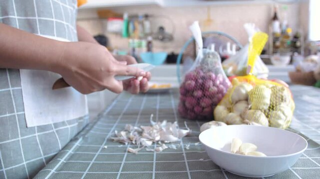 Close-up shot hand of the people is peeling the garlic
