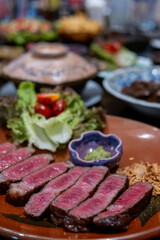 Medium rare sliced rib eye meat served on plate with vegetable