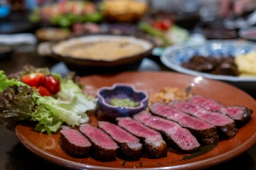 Medium rare sliced rib eye meat served on plate with vegetable