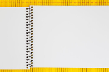 blank page of sketch book laying on yellow bamboo mat